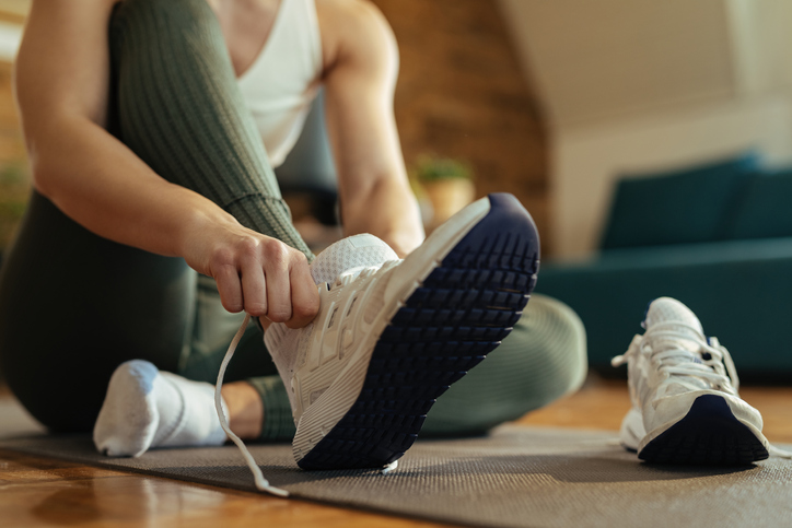 Close-up of athletic woman putting on sneakers. Movement Therapy
